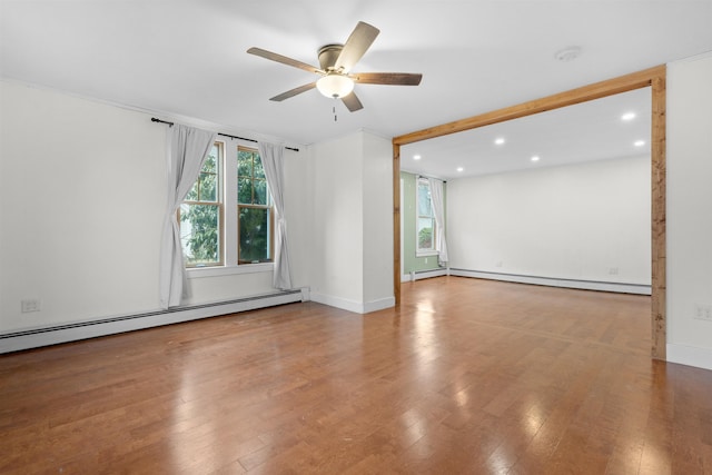 unfurnished room featuring hardwood / wood-style flooring, a baseboard radiator, and ceiling fan