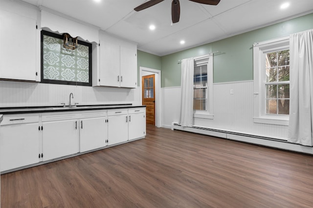 kitchen with sink, ceiling fan, baseboard heating, white cabinets, and dark hardwood / wood-style flooring