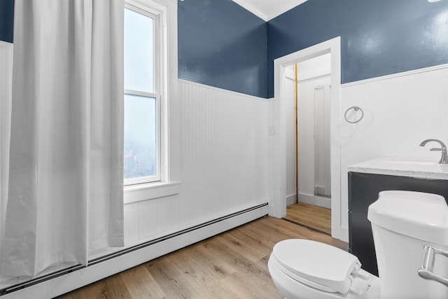 bathroom with a baseboard radiator, toilet, sink, and hardwood / wood-style floors