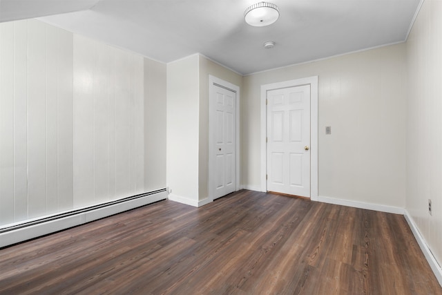 empty room featuring dark wood-type flooring and a baseboard radiator