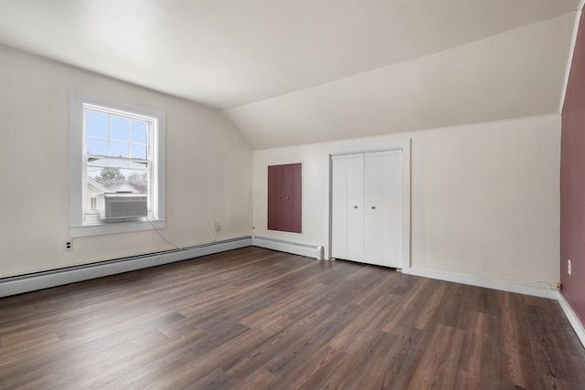 additional living space with baseboard heating, dark hardwood / wood-style flooring, vaulted ceiling, and cooling unit