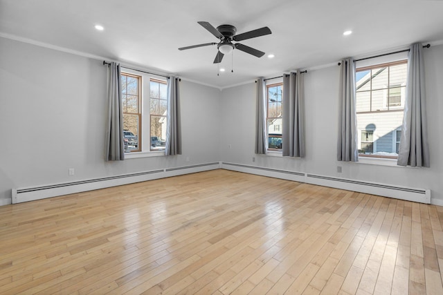 empty room with ornamental molding, light hardwood / wood-style flooring, and a baseboard heating unit