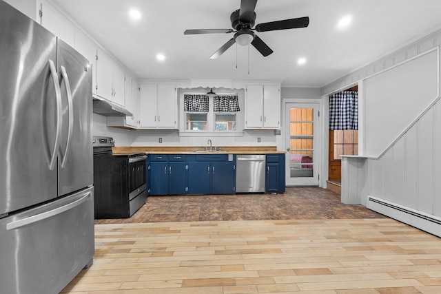 kitchen with blue cabinets, sink, butcher block countertops, appliances with stainless steel finishes, and white cabinets