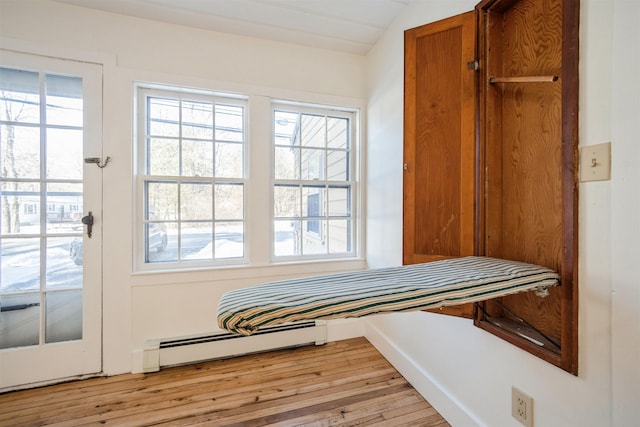 mudroom featuring plenty of natural light, a baseboard heating unit, and light wood-type flooring