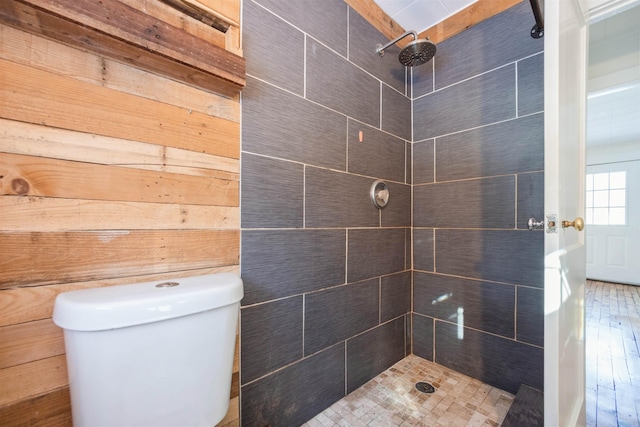 bathroom with a tile shower, hardwood / wood-style flooring, and toilet