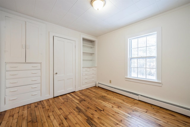 unfurnished bedroom featuring a baseboard radiator, ornamental molding, and light wood-type flooring