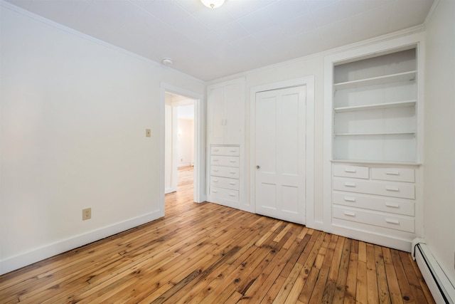 unfurnished bedroom featuring light hardwood / wood-style flooring, ornamental molding, a closet, and baseboard heating