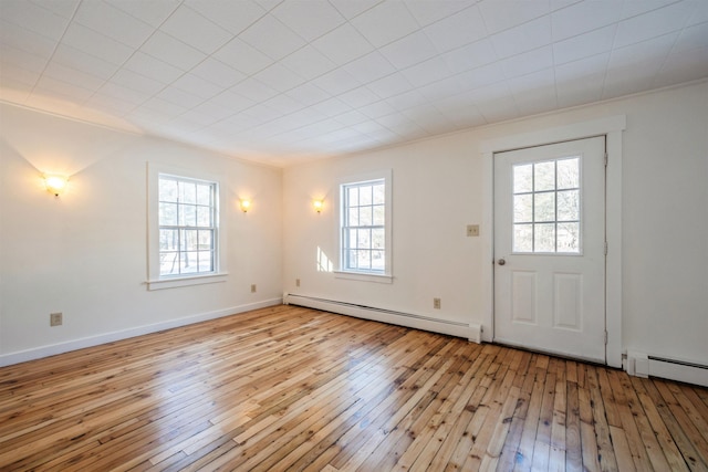 interior space featuring plenty of natural light, baseboard heating, and light hardwood / wood-style flooring