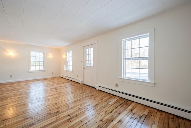 foyer entrance with light wood-type flooring and a baseboard heating unit