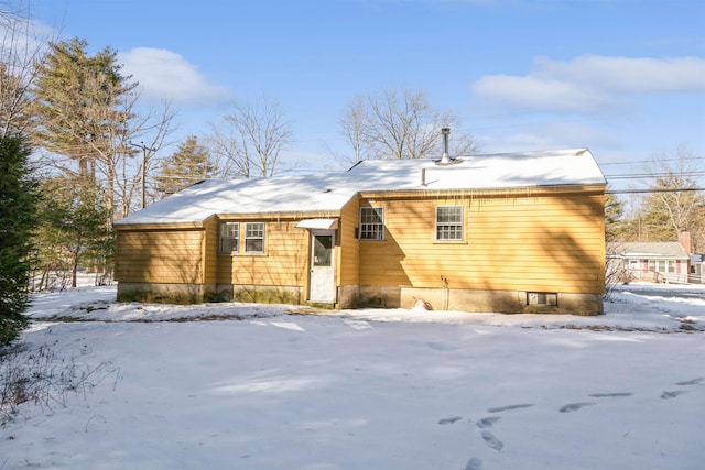 view of snow covered back of property