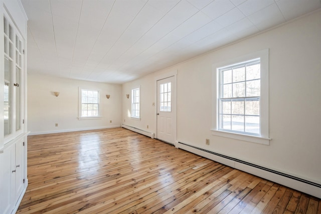 interior space with light wood-type flooring and baseboard heating