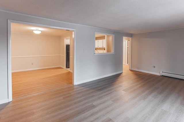 empty room with wood-type flooring, ornamental molding, and a textured ceiling