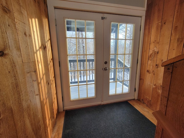 entryway featuring french doors, wood-type flooring, and wood walls