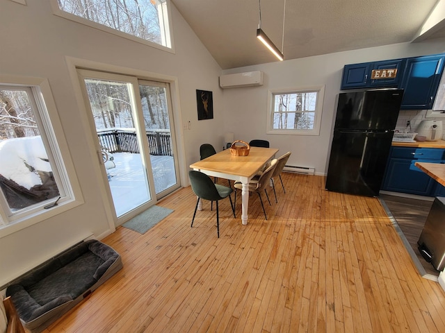 dining space with high vaulted ceiling, a wall unit AC, baseboard heating, and light hardwood / wood-style floors