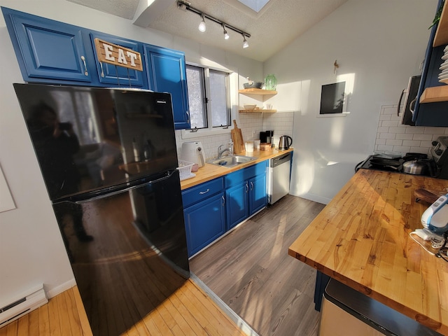 kitchen featuring baseboard heating, blue cabinetry, stainless steel appliances, and butcher block countertops