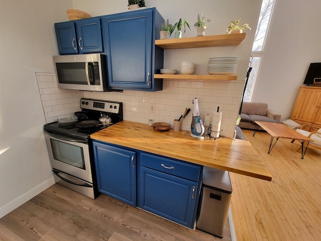 kitchen featuring blue cabinets, appliances with stainless steel finishes, and wood counters