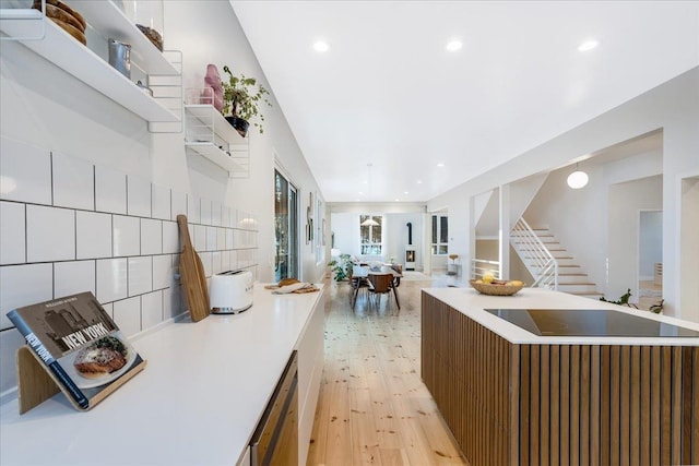 kitchen with tasteful backsplash, dishwasher, light hardwood / wood-style floors, and a kitchen island