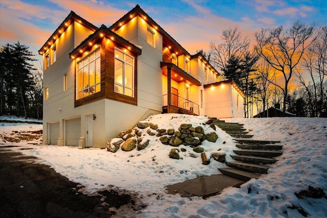 snow covered property featuring a garage