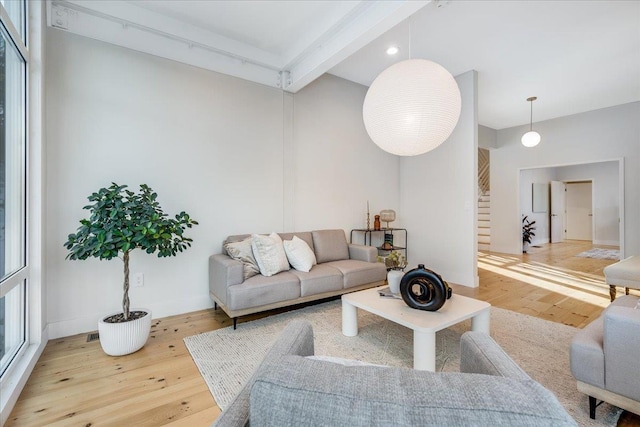 living room featuring beamed ceiling and wood-type flooring