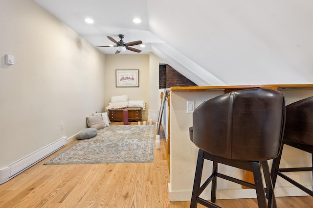 interior space with baseboard heating, lofted ceiling, and light wood-type flooring