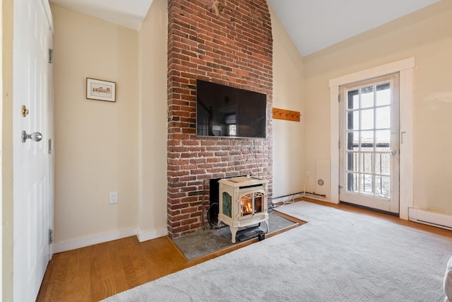 unfurnished living room with hardwood / wood-style flooring, vaulted ceiling, and a wood stove