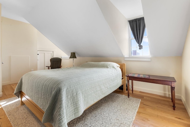 bedroom featuring lofted ceiling and light wood-type flooring