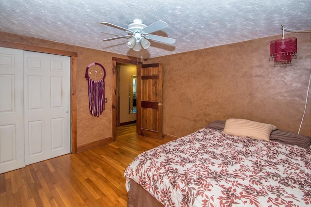 bedroom featuring hardwood / wood-style flooring, ceiling fan, and a textured ceiling