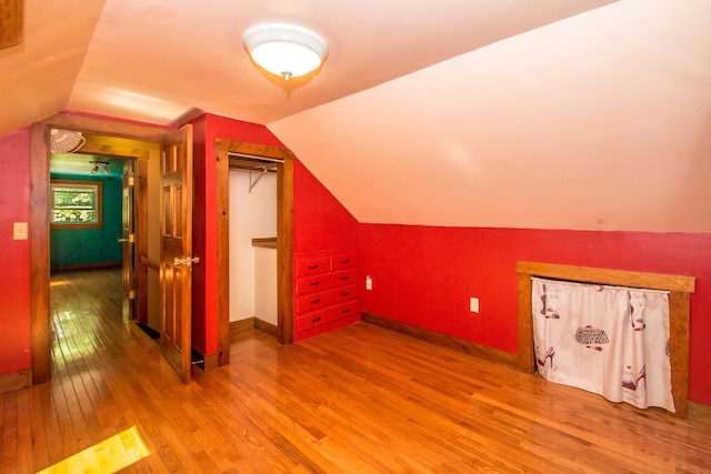 bonus room with lofted ceiling and hardwood / wood-style floors