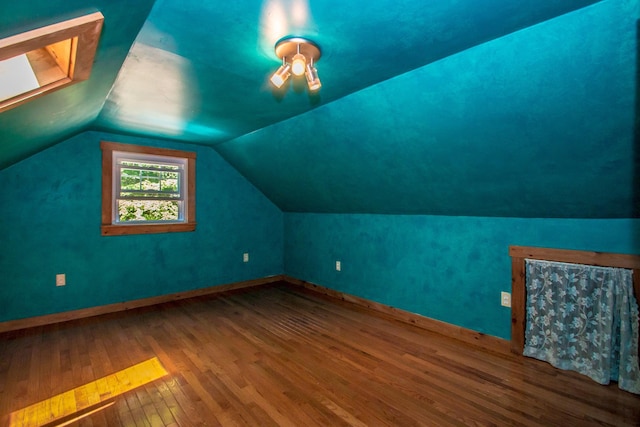 additional living space featuring wood-type flooring and vaulted ceiling