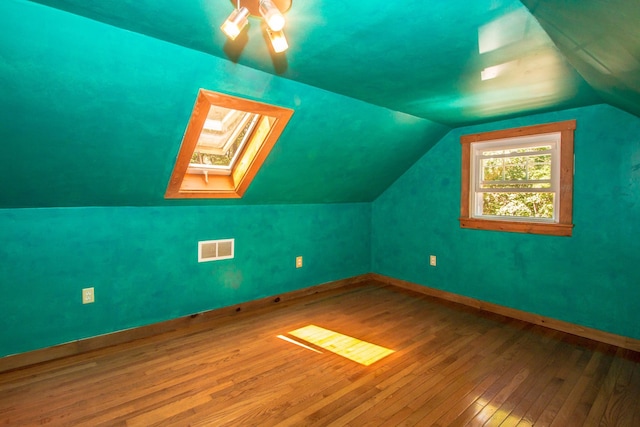 bonus room featuring hardwood / wood-style flooring and lofted ceiling with skylight