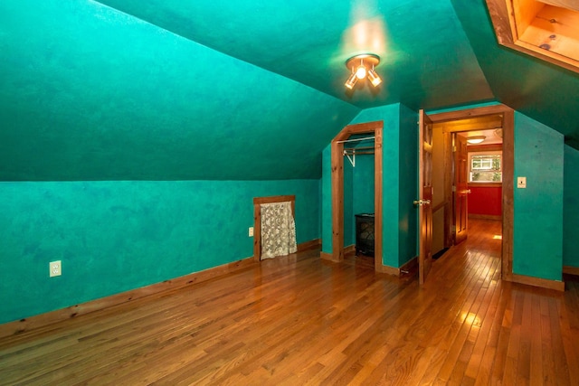 bonus room featuring wood-type flooring and vaulted ceiling