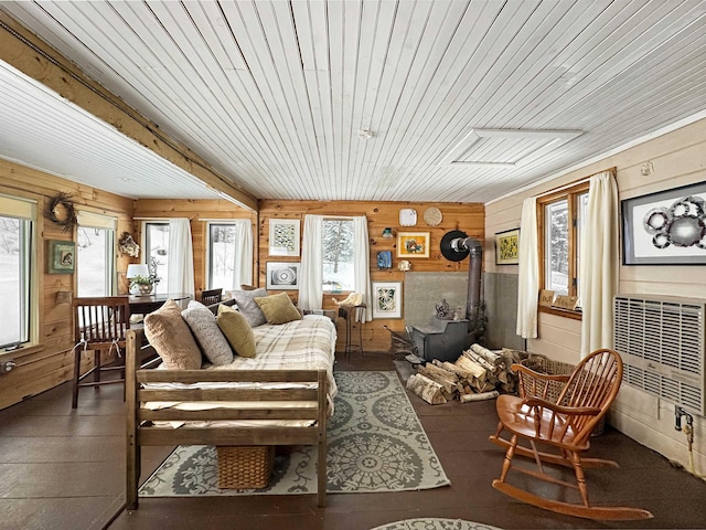 living room featuring wooden ceiling, wooden walls, and a wood stove