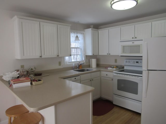 kitchen featuring sink, hanging light fixtures, kitchen peninsula, white appliances, and white cabinets