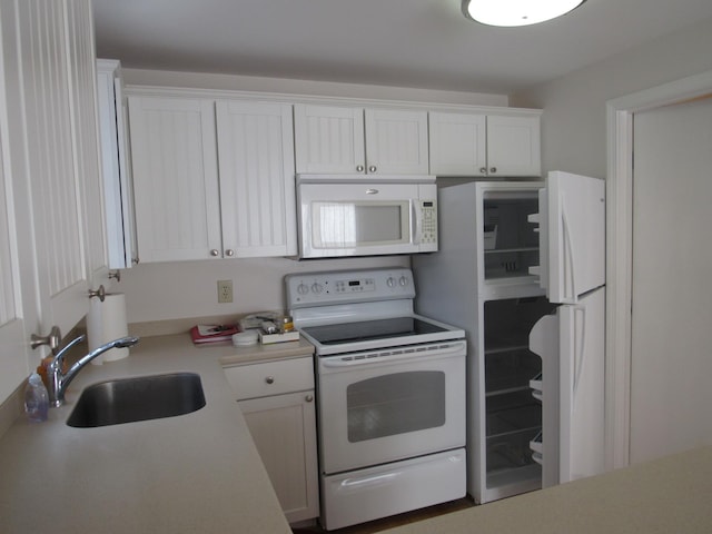 kitchen with sink, white cabinets, and white appliances