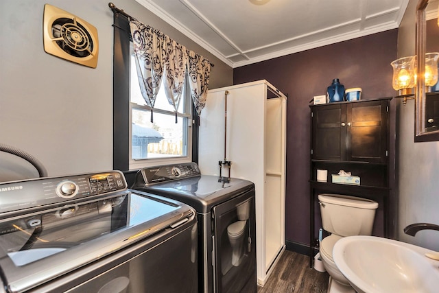 washroom with crown molding, washing machine and clothes dryer, dark hardwood / wood-style flooring, and sink