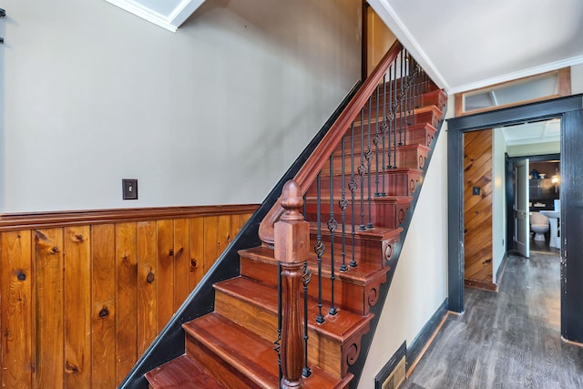 stairway featuring hardwood / wood-style floors and wood walls