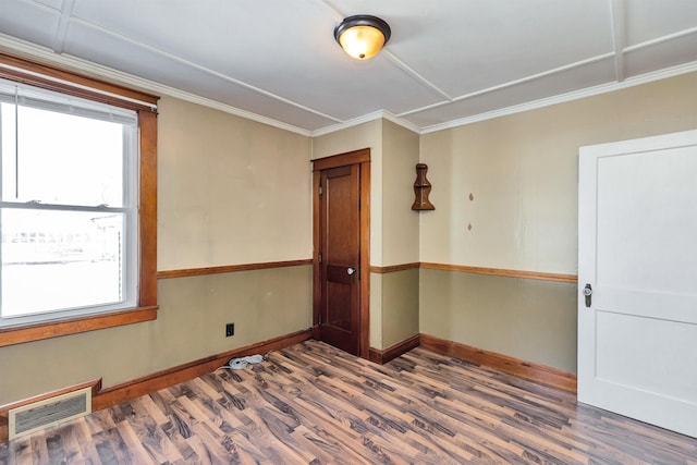 empty room featuring ornamental molding and hardwood / wood-style floors