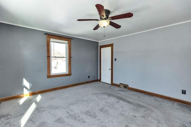 carpeted spare room featuring ceiling fan and ornamental molding