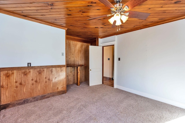 spare room with crown molding, wood ceiling, light colored carpet, and ceiling fan