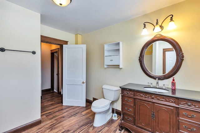 bathroom with vanity, toilet, and hardwood / wood-style floors