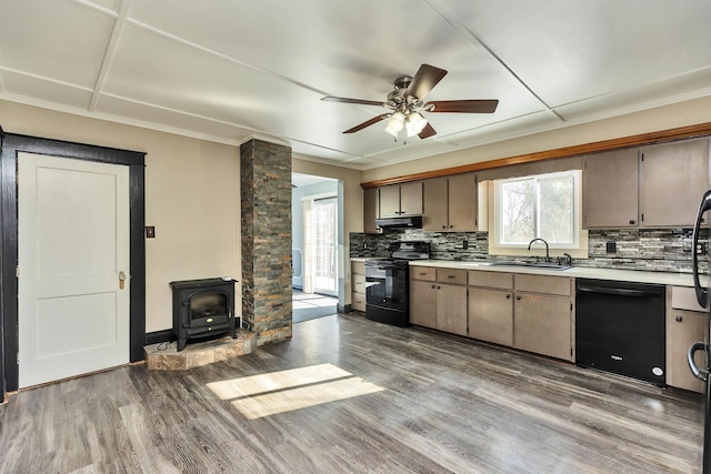 kitchen featuring hardwood / wood-style flooring, sink, backsplash, and black appliances