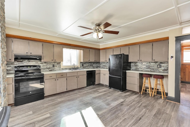 kitchen with light hardwood / wood-style flooring, backsplash, and black appliances