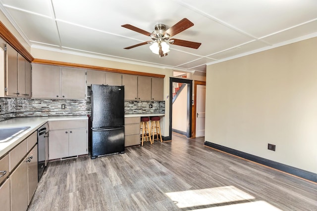 kitchen with tasteful backsplash, crown molding, black appliances, and light hardwood / wood-style floors