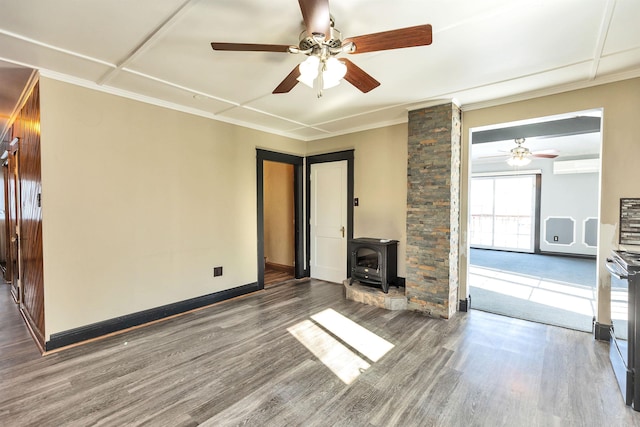 unfurnished living room featuring ornamental molding, a wood stove, ceiling fan, and dark hardwood / wood-style floors