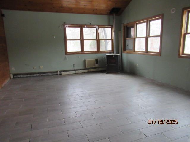 empty room featuring wood ceiling, a wall mounted AC, and vaulted ceiling