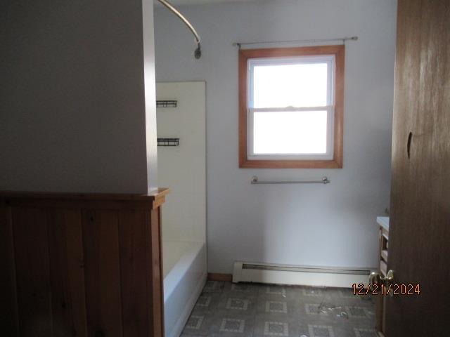 bathroom with vanity, a baseboard heating unit, and washtub / shower combination