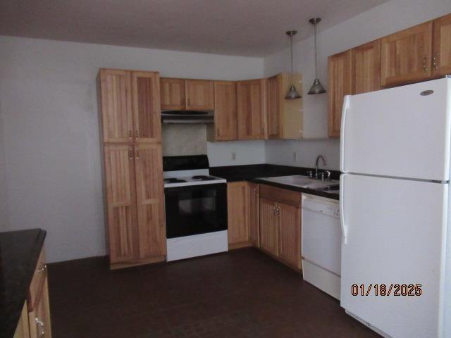 kitchen with sink, pendant lighting, and white appliances