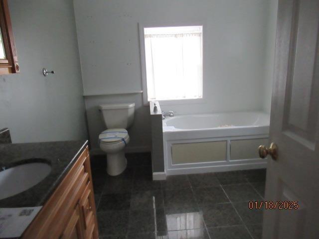 bathroom with vanity, tile patterned flooring, a tub, and toilet