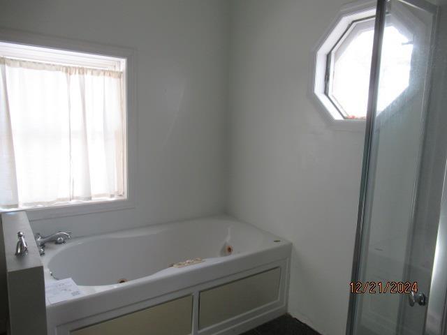 bathroom featuring a bath and plenty of natural light