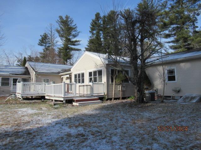 rear view of house with cooling unit and a deck